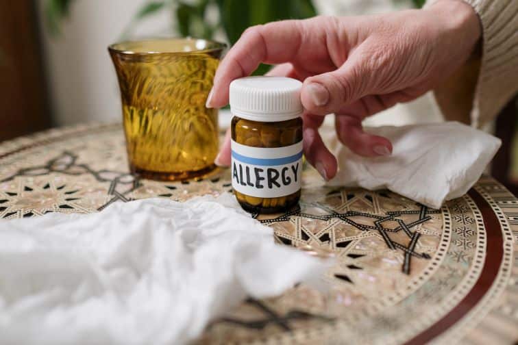 An allergy pill bottle amongst tissues
