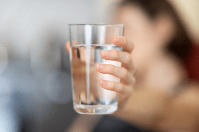 Woman holds glass of water