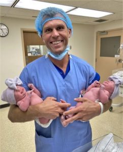 Dr. Jon holding his newborn twin girls