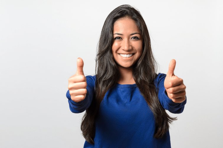 Woman in blue shirt giving two thumbs up