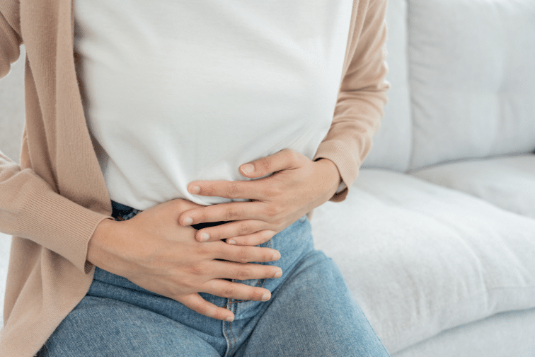 Woman placing hands on upset stomach